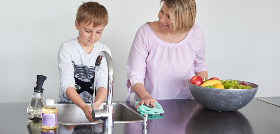 Mother cleaning with ENJO alongside son in the kitchen